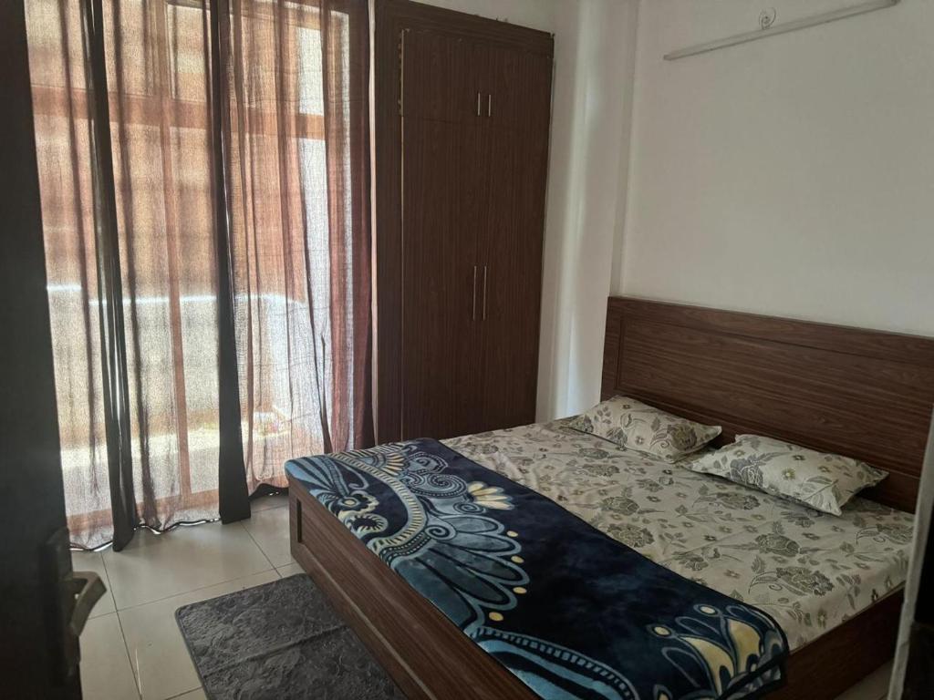 a bedroom with a bed in a room with windows at Visitor stop in Greater Noida