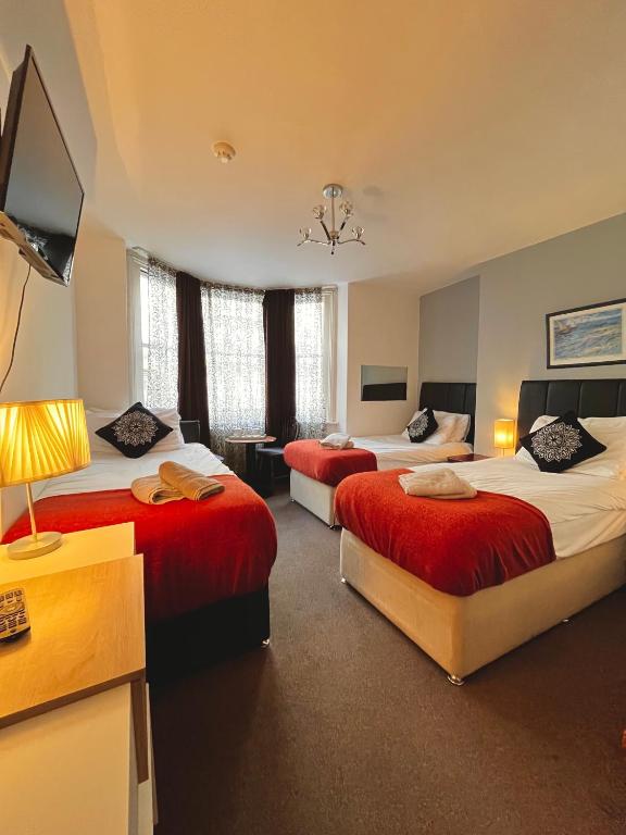 a hotel room with two beds and a television at Old Palace Guest House in Brighton & Hove