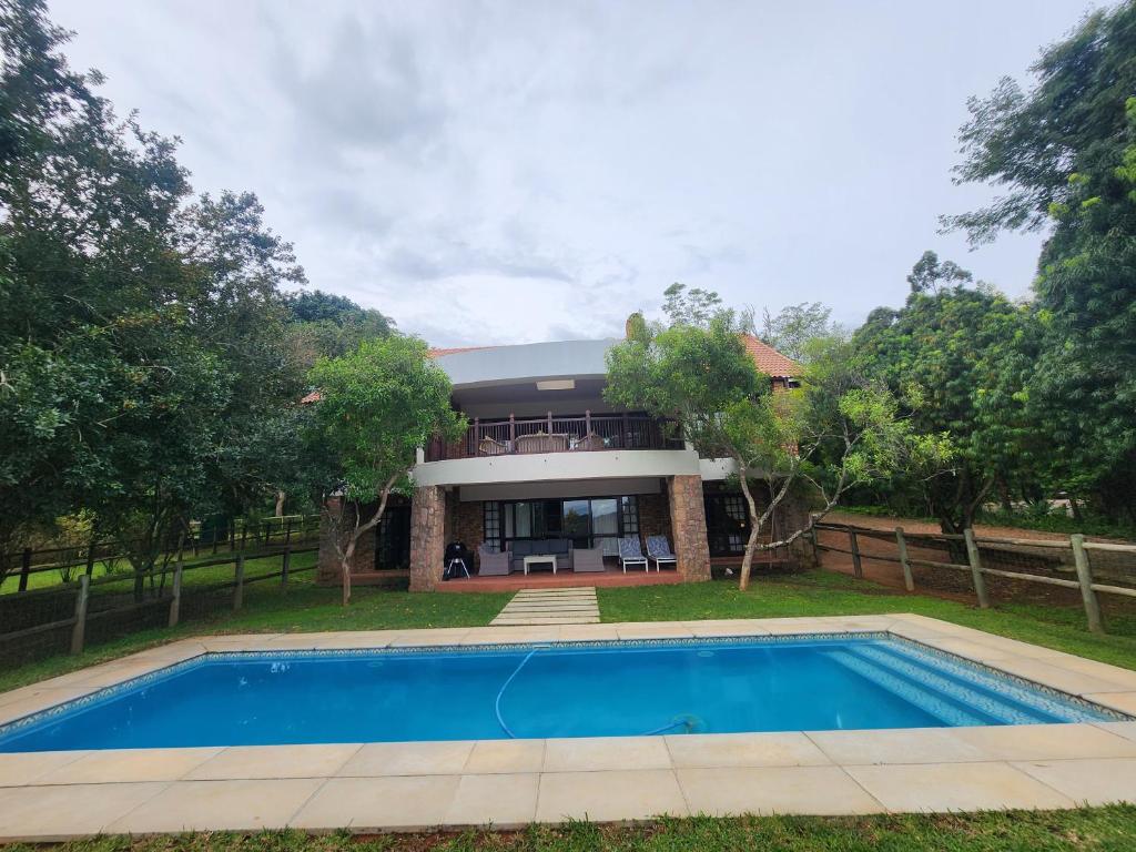 a house with a swimming pool in front of it at Golf Estate Vacation Property - Poseidon's Knoll in White River