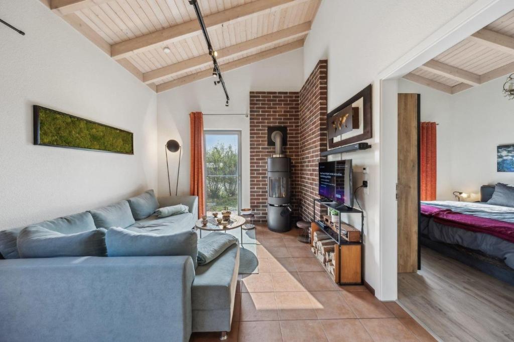 ein Wohnzimmer mit einer Couch und einem Bett in der Unterkunft PINTO ROSSO - rotes Strandhaus an idyllischem Privatsee in Twist