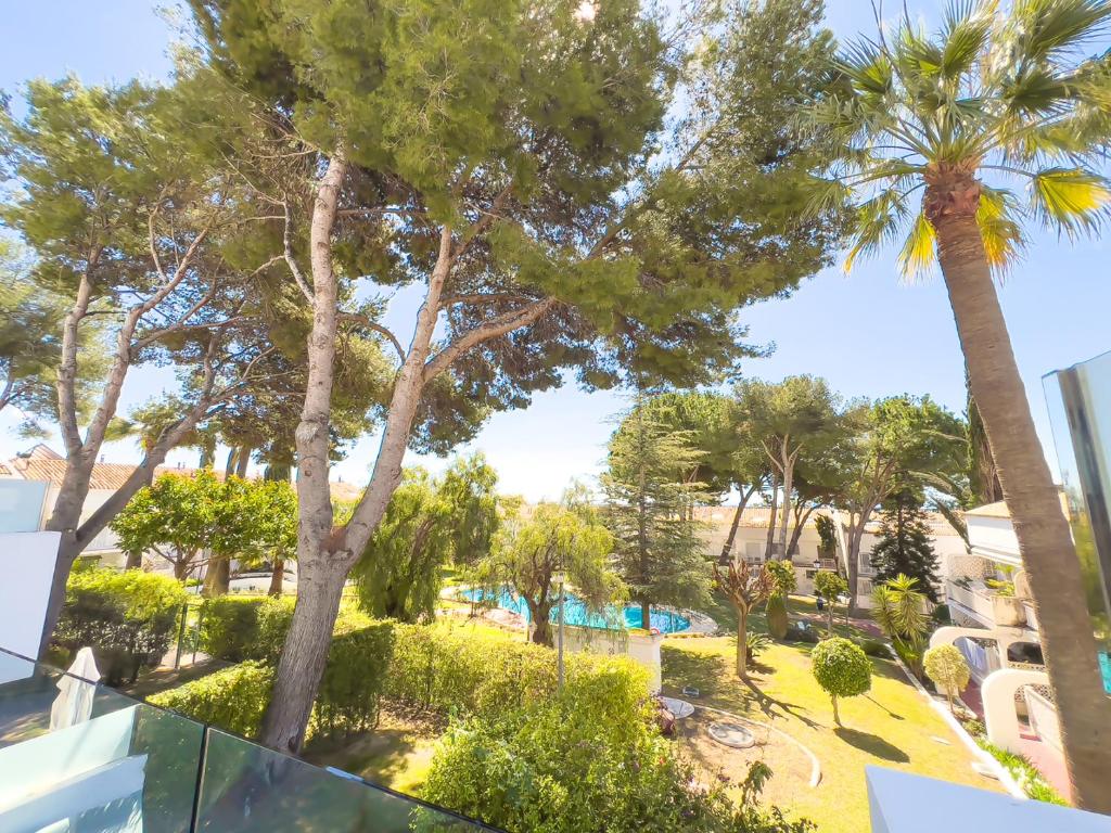 Una vista desde el balcón de un resort con palmeras. en Apartment on the Golden Mile, en Marbella