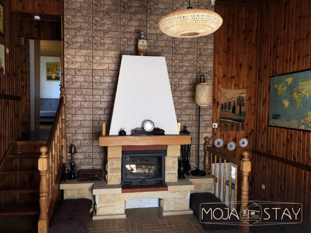 a living room with a fireplace and a staircase at Moja Stay - wyjątkowy dom z sauną in Niesulice