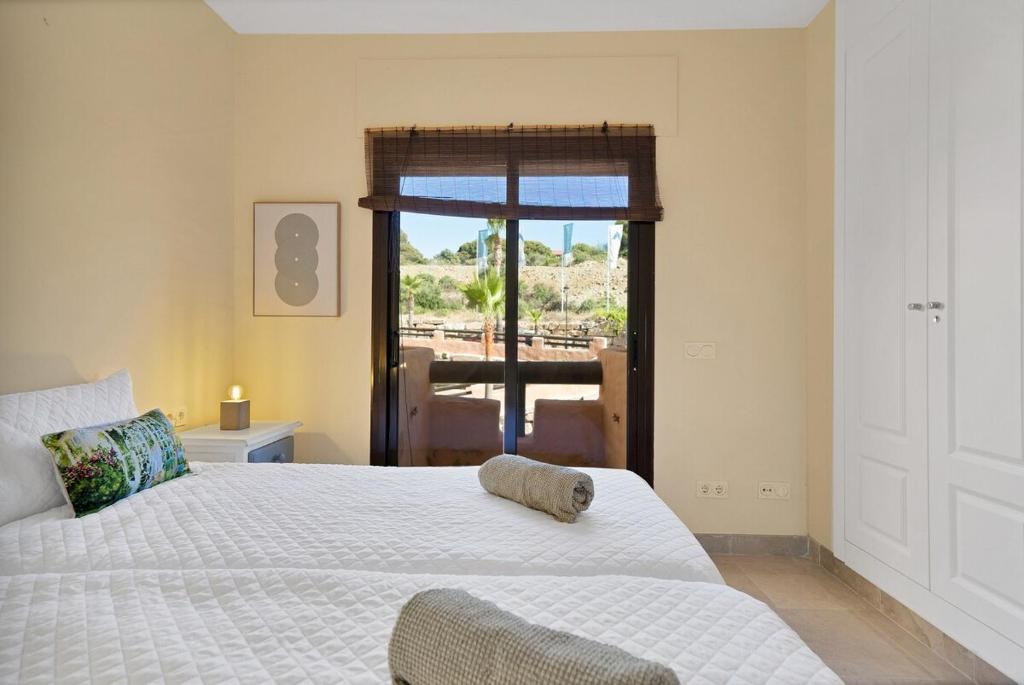 una camera da letto con un letto bianco e una finestra di Ocean view apartment en la duquesa golf - COTO REAL 321 a Manilva