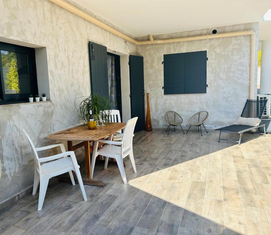 une table et des chaises en bois sur une terrasse dans l'établissement Bas de villa au calme absolu, à La Crau