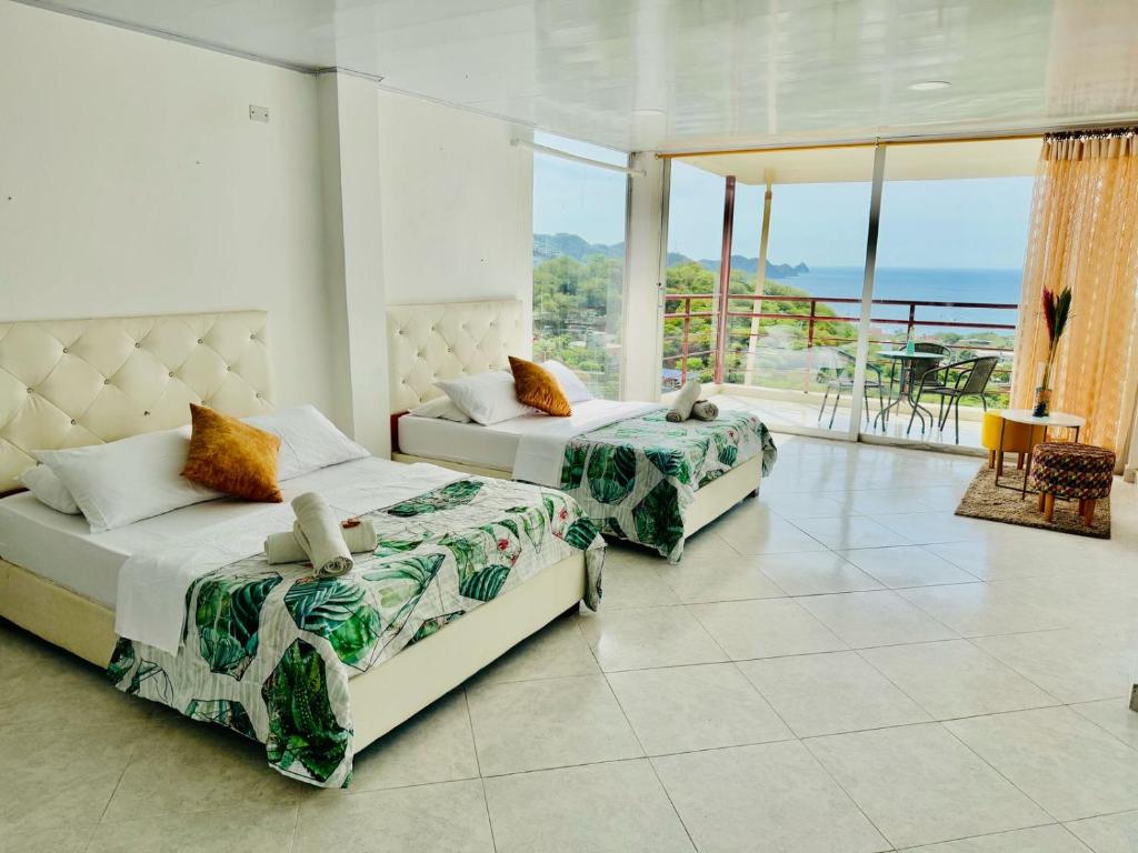 zwei Betten in einem Zimmer mit Meerblick in der Unterkunft Casa Relax - Adults Only in Taganga
