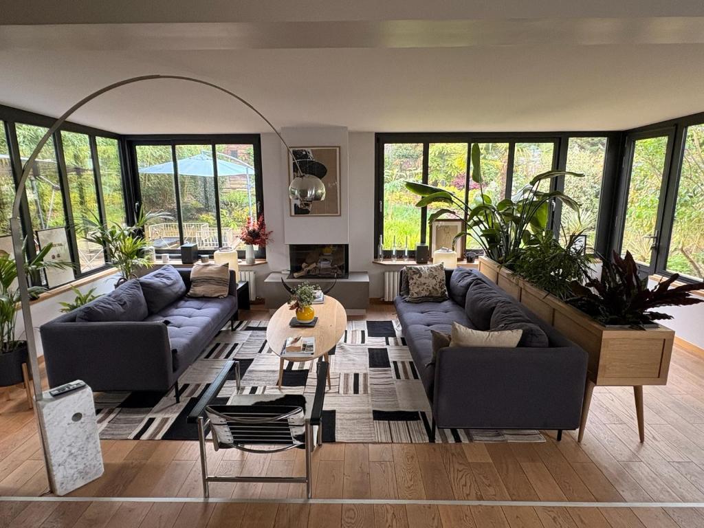 un salon avec des canapés et une table dans l'établissement Villa à Louveciennes, à Louveciennes
