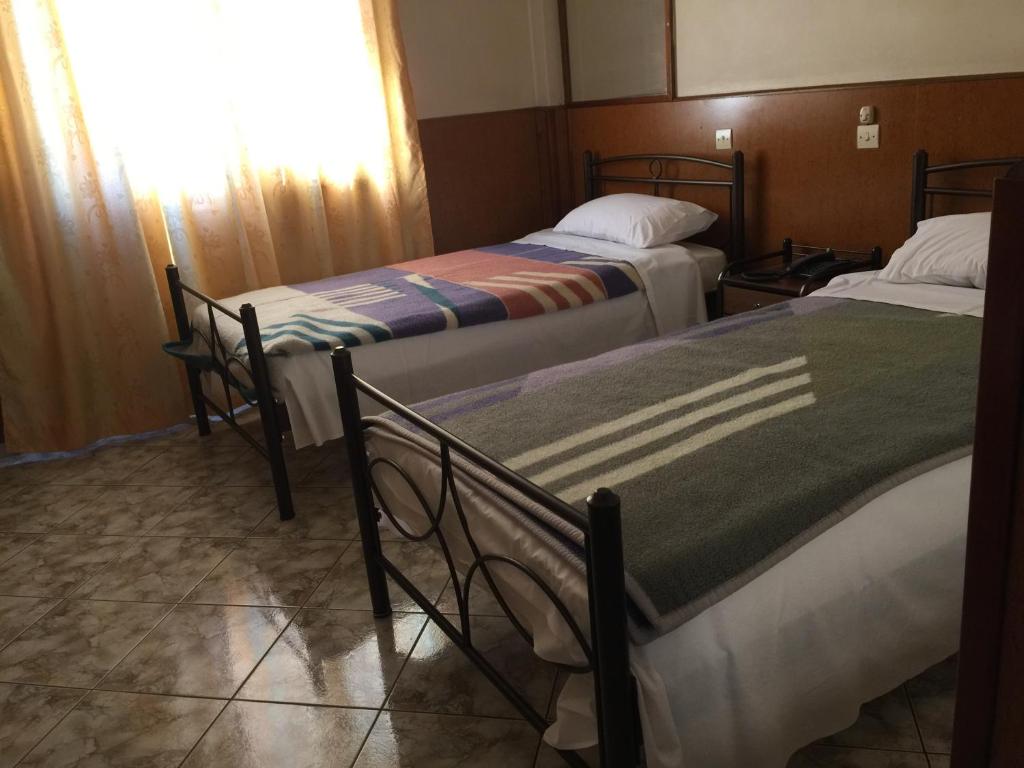 Postel nebo postele na pokoji v ubytování Aegli Hotel