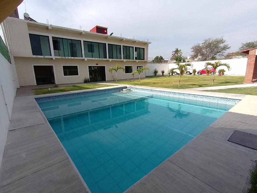 a swimming pool in front of a house at Temixco para fin de semana ! in Temixco