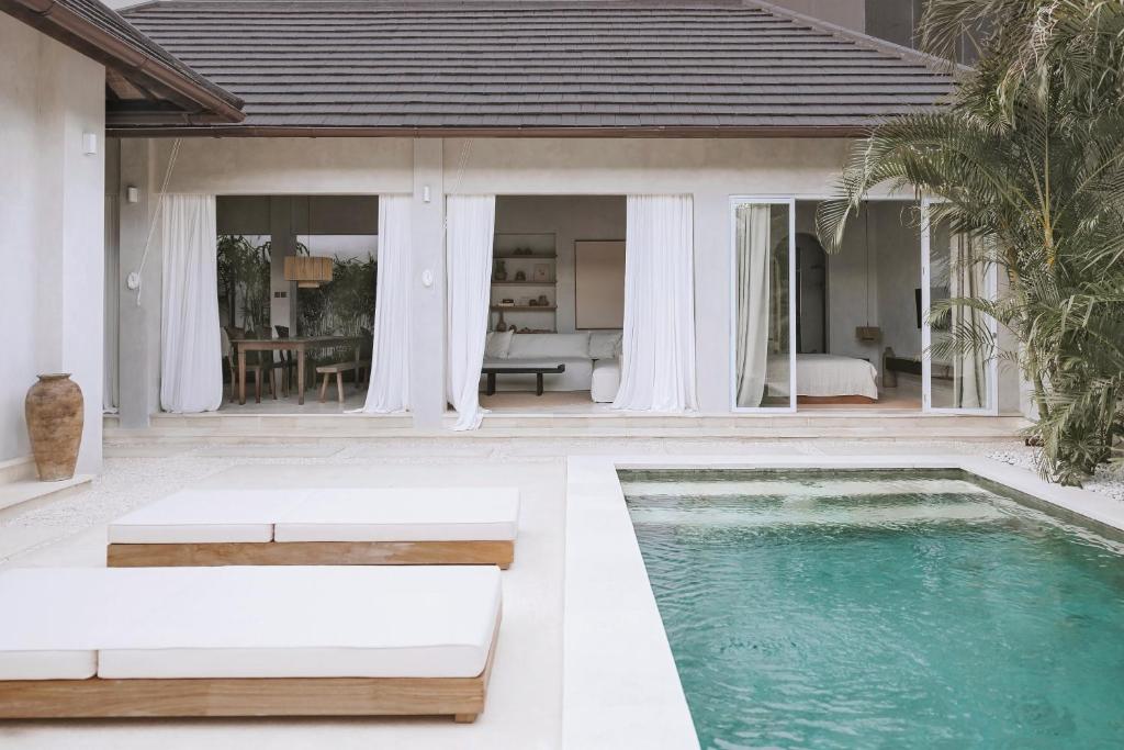 una villa con piscina y una casa en Designer 3BR Villa Tropical Stay Near Canggu, en Kerobokan