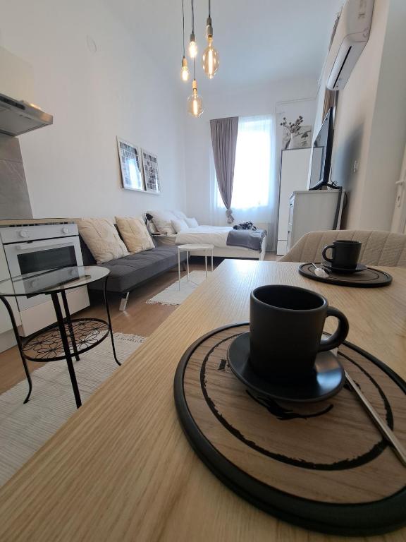 a coffee cup sitting on a table in a living room at CozyCentralApartment in Kecskemét
