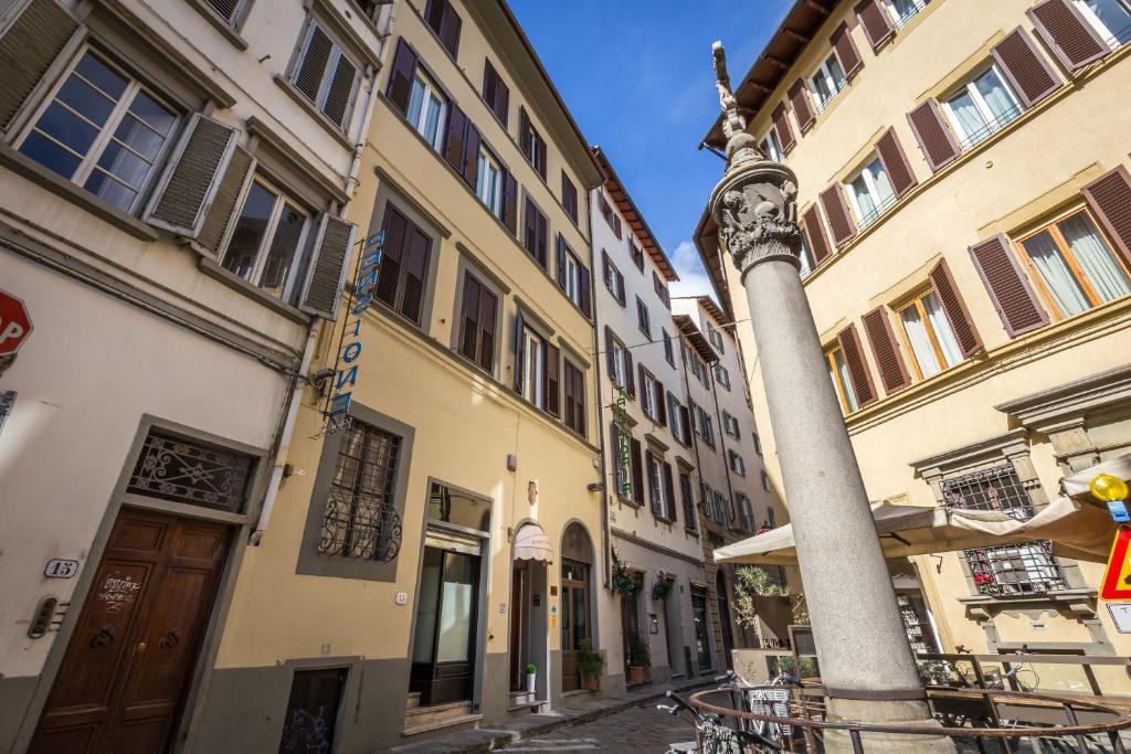 un poste en medio de una calle con edificios en Hotel Ferretti, en Florencia