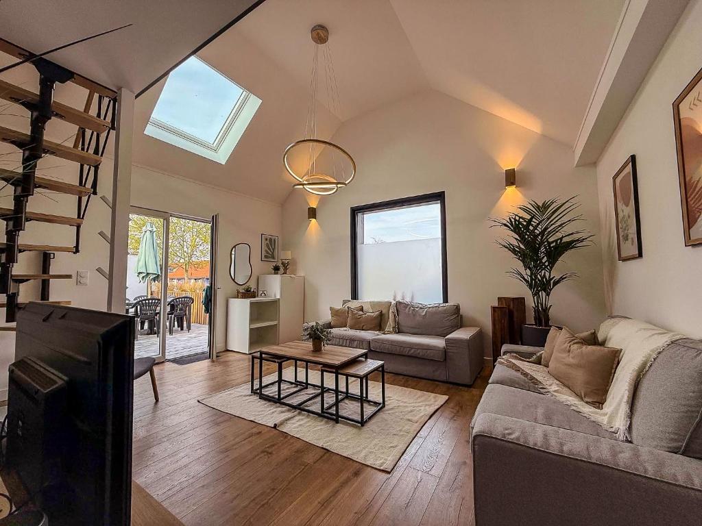 un salon avec un canapé et une table dans l'établissement Maison avec jardin à 50m du Lac, à Ardres