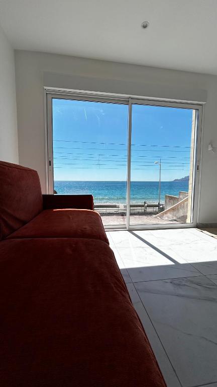 un salon avec un canapé et une vue sur l'océan dans l'établissement La Pitchounette bord de mer, à Cannes