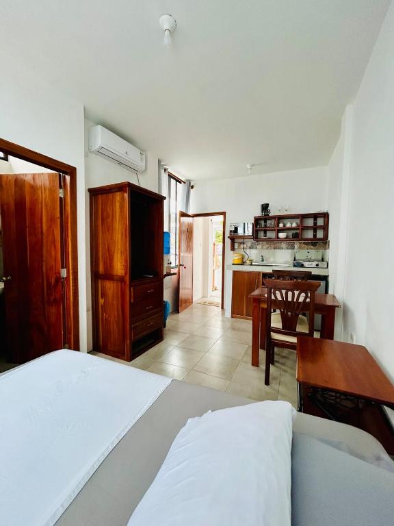 a bedroom with a bed and a table and a kitchen at Suite Economy in Puerto Ayora