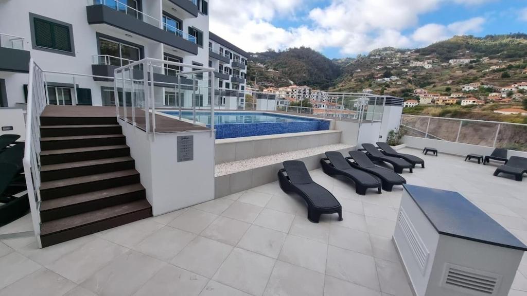 a balcony with lounge chairs and a swimming pool at Pestana Green View in Caniço