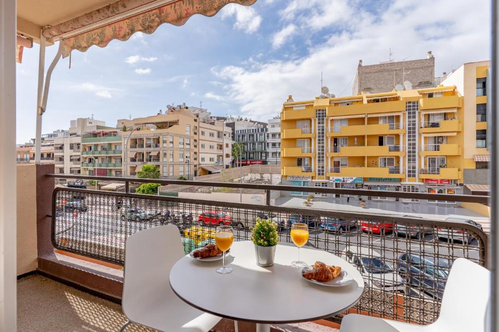 Un balcón con mesa y sillas y vista a una ciudad. en Apartment in Los Cristianos by the beach, en Los Cristianos