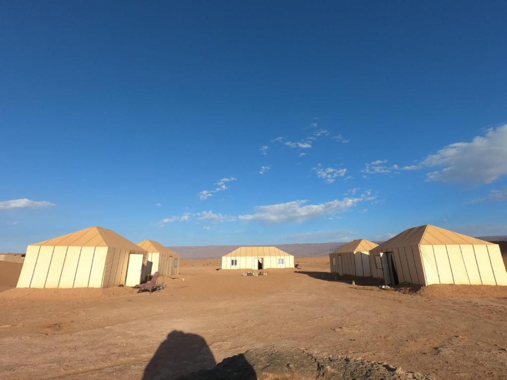 un gruppo di edifici in un deserto con un cielo blu di Camp Les Bedouins iriki a Bou Guir