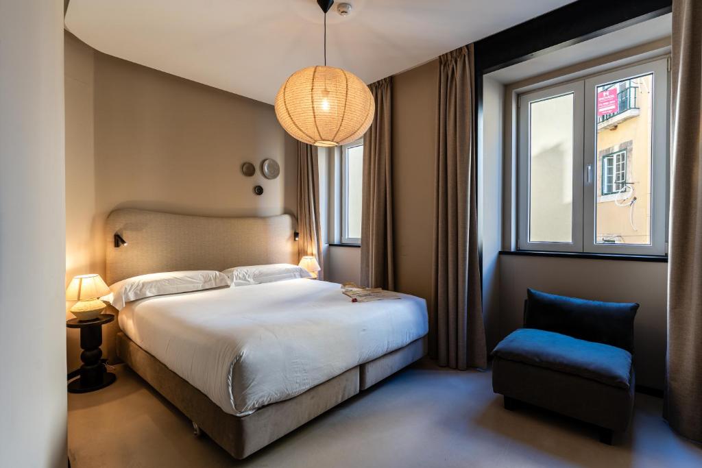 リスボンにあるCasa Teva Lisboa Boutique Hotel by chic&basicのベッドルーム(大型ベッド1台、青い椅子付)