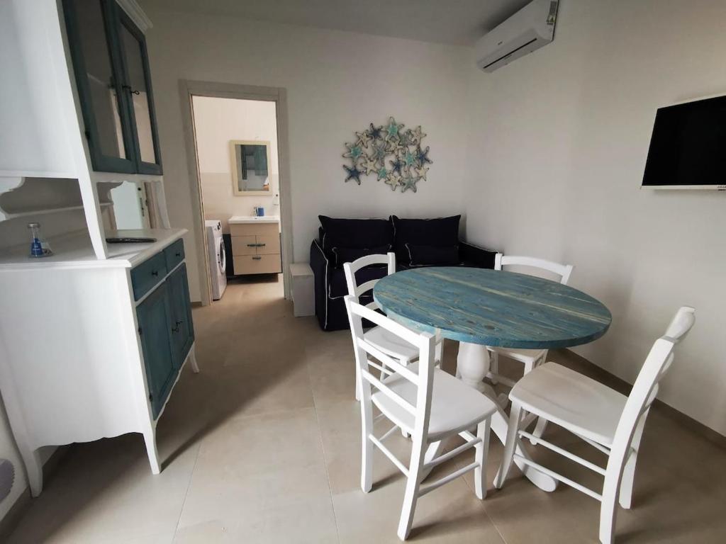 Una cocina y un comedor con mesa y sillas. en Borgo Celentano, en Torre Lapillo