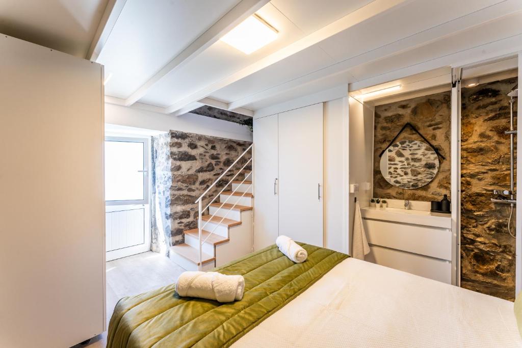 ein Schlafzimmer mit einem grünen Bett und einer Treppe in der Unterkunft Social Lodge Galinho House in Estreito da Calheta