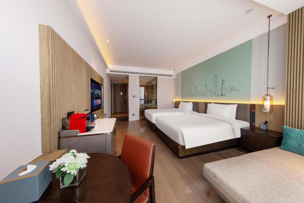 Postel nebo postele na pokoji v ubytování UrCove by HYATT Shenzhen Luohu