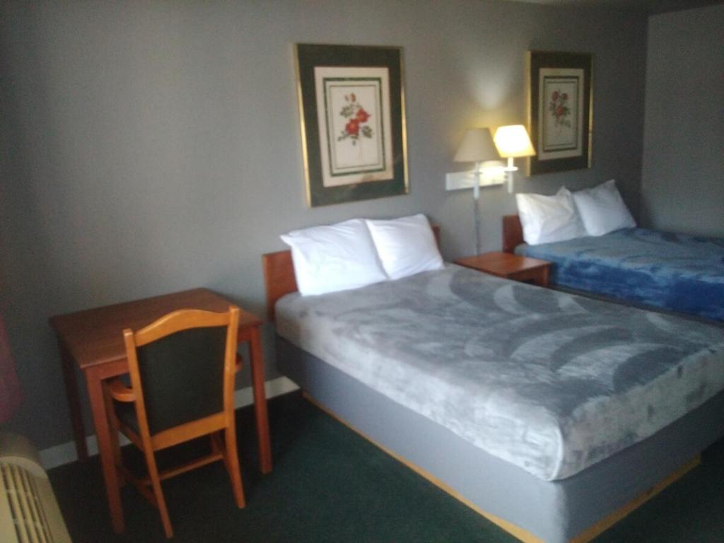 a hotel room with two beds and a table and a chair at King Bed Hotel Studio 102 in Livingston