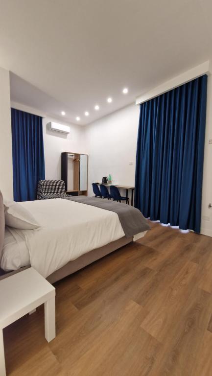 ein Schlafzimmer mit einem großen Bett und blauen Vorhängen in der Unterkunft B&B City Center in Neapel