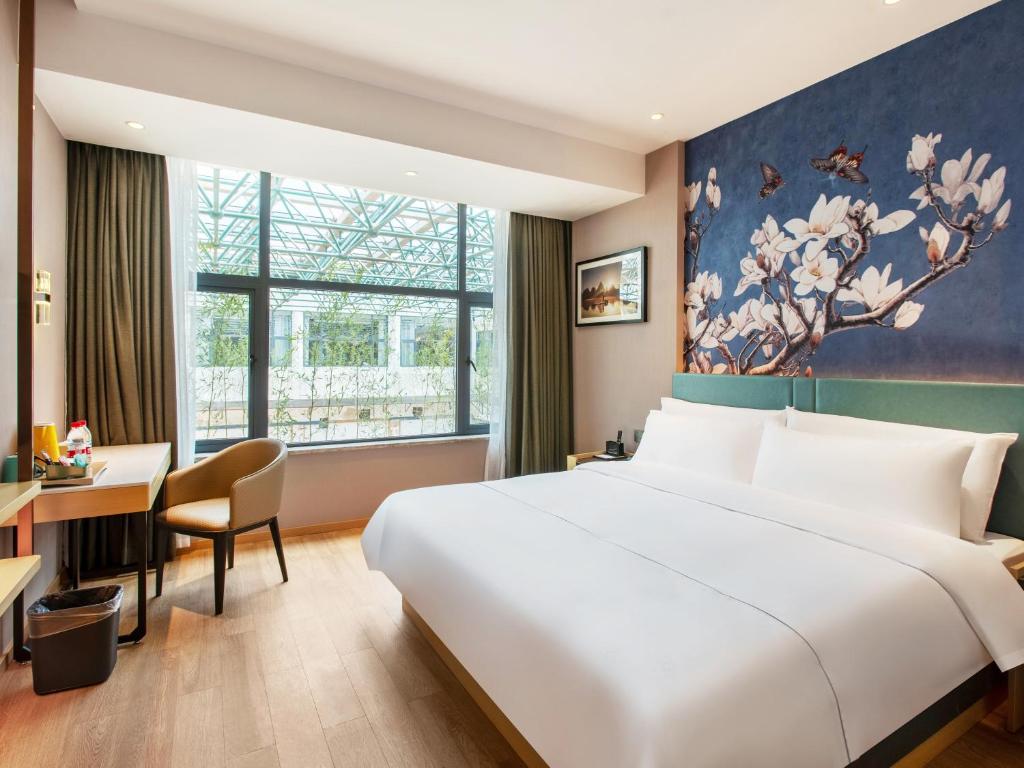 Postel nebo postele na pokoji v ubytování Guilin Magnotel Classic Hotel By Seven Star Park, Li River