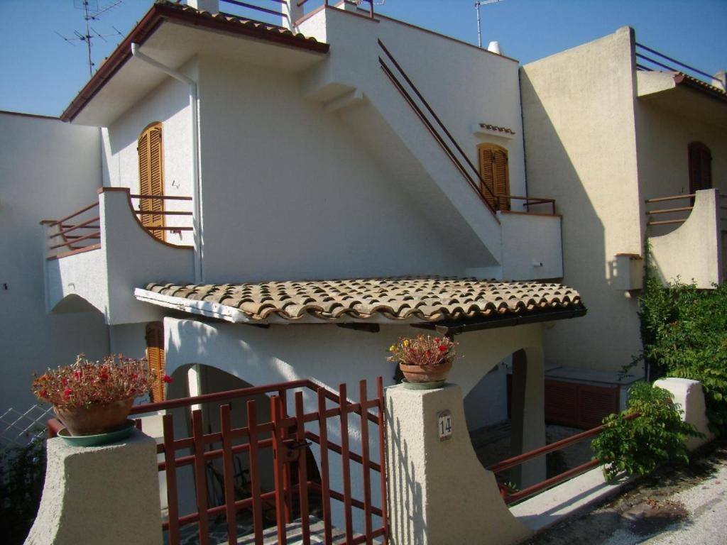 a white house with stairs and a fence at Villetta Elena Via Loreto 64 villa 14 in Marcelli