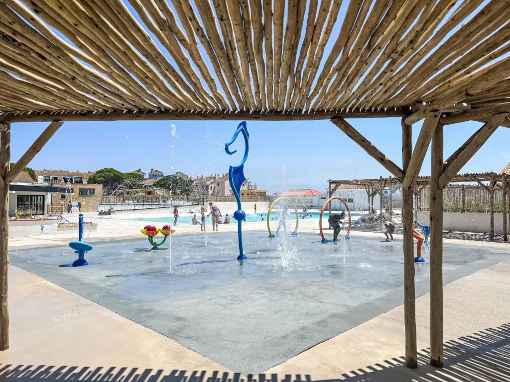 une piscine avec un parc aquatique doté d'une fontaine dans l'établissement Apartment Coudalère-Guadeloupe-14 by Interhome, au Barcarès