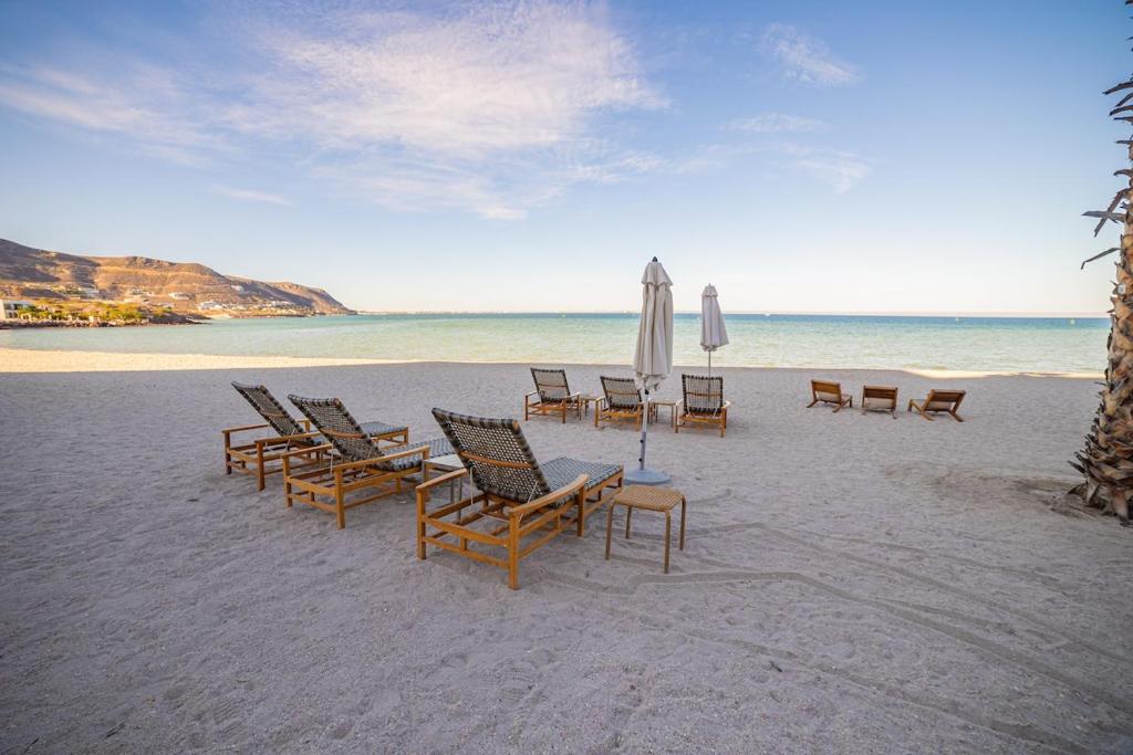 - un groupe de chaises et un parasol sur une plage dans l'établissement Villa #7 at Puerta Cortes Resort! Golf - Beachclub, à La Paz