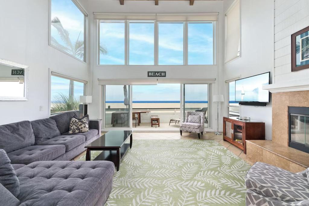 un salon avec un canapé et une cheminée dans l'établissement Spacious Oceanfront Home Near Newport Pier, à Newport Beach