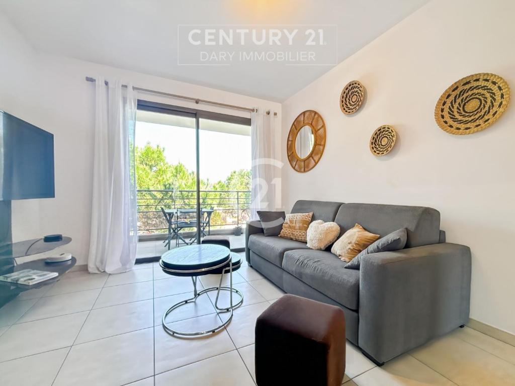 un salon avec un canapé et une table dans l'établissement Résidence Grand Large - Appartement T3 proche de la plage de Calvi, à Calvi