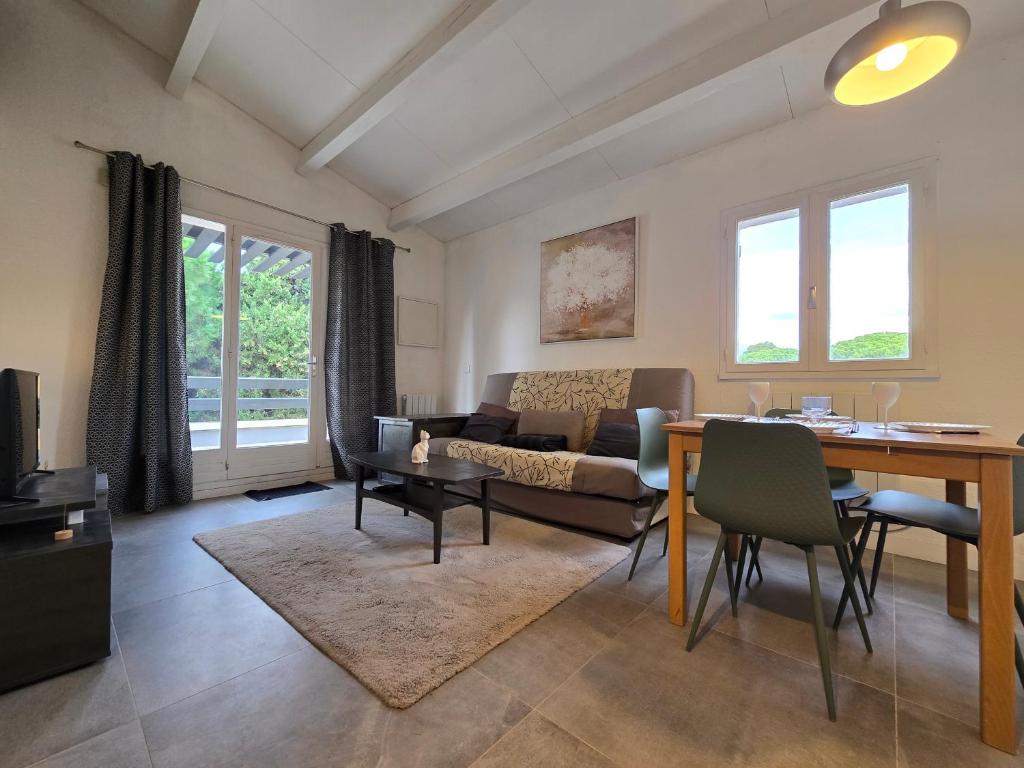 un salon avec une table et un canapé dans l'établissement Joli appartement T2 cabine avec parking et wifi Tennis Village, au Cap d'Agde