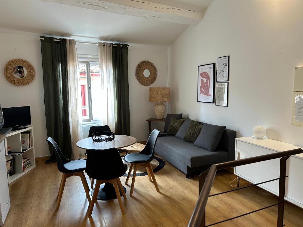 un salon avec un canapé, une table et des chaises dans l'établissement Appartement rénové à 50 m de COLLIOURE Plage, Entrée autonome, Climatisé, à Collioure
