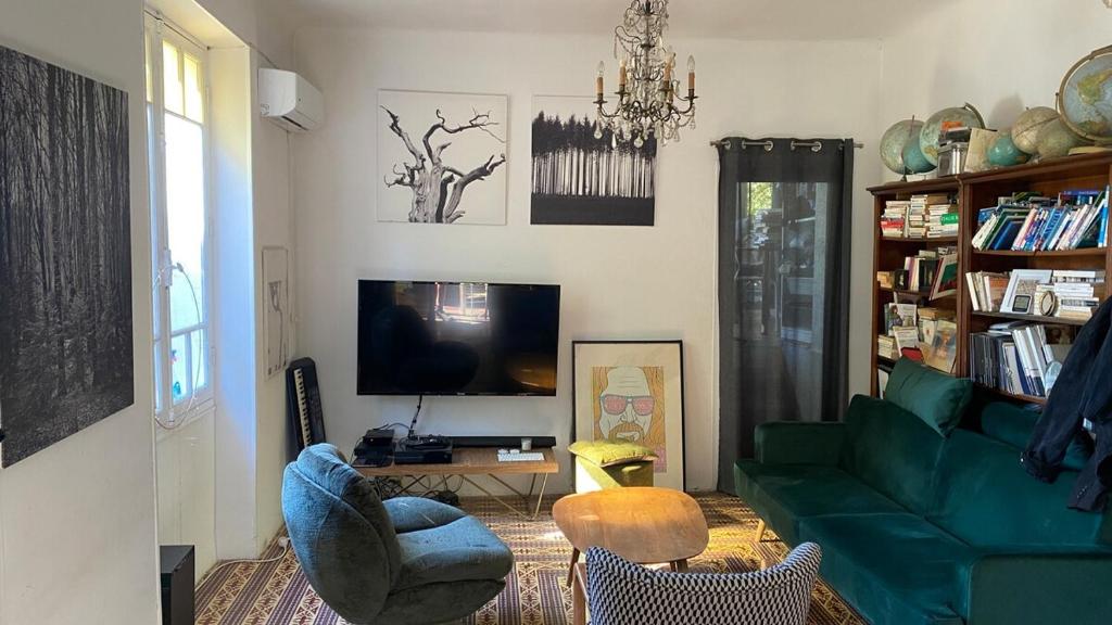 - un salon avec un canapé vert et une télévision dans l'établissement Etage de maison centre-ville Aix en Provence, à Aix-en-Provence