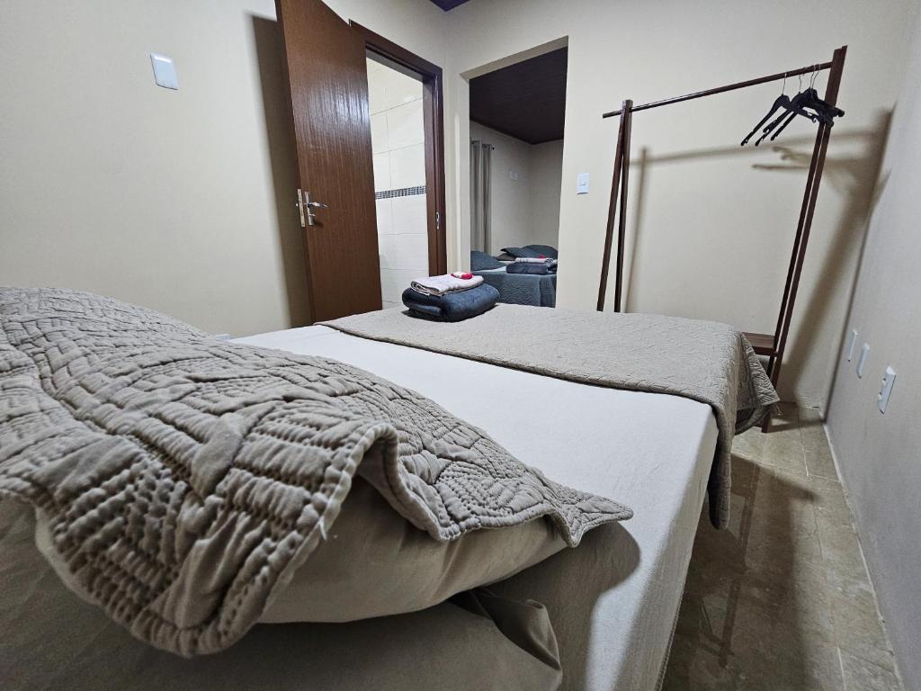 a bedroom with a bed with a blanket on it at Hospedagem Costa BNU - Q1 in Blumenau
