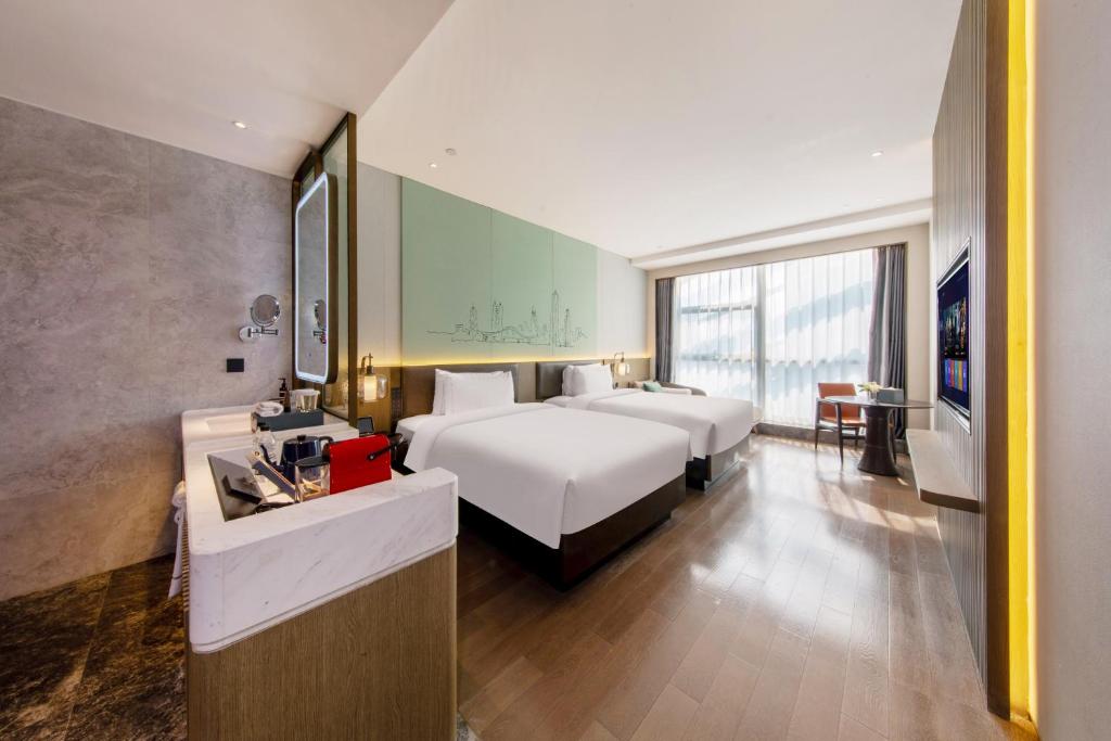 Postel nebo postele na pokoji v ubytování UrCove by HYATT Shenzhen Luohu
