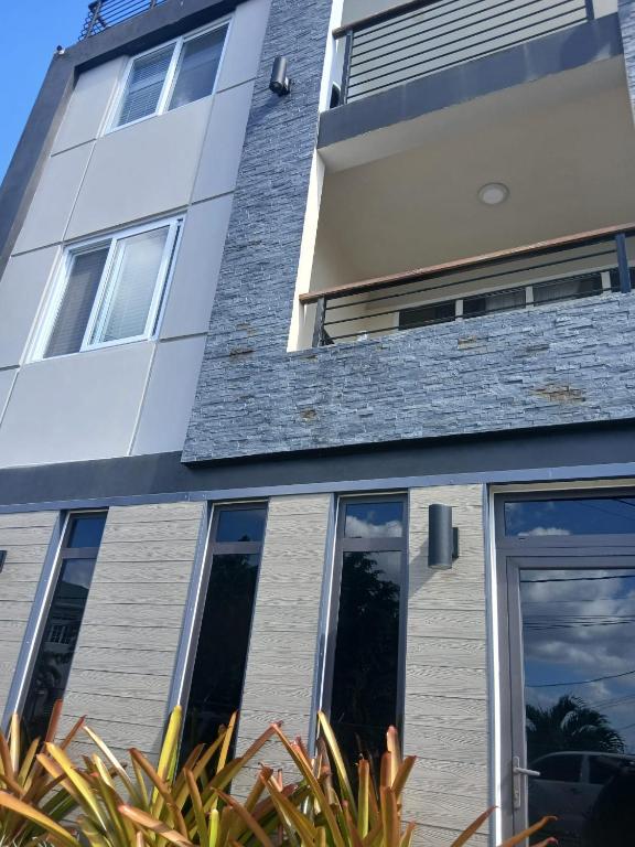 un bâtiment avec de grandes fenêtres et des plantes devant lui dans l'établissement Cypress Suites, à Goodwill