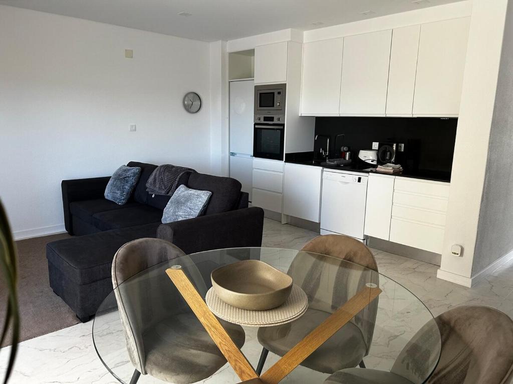 a living room with a glass table and chairs at One-bedroom in Alvor with a Sea View Fully Renovated in Bicas