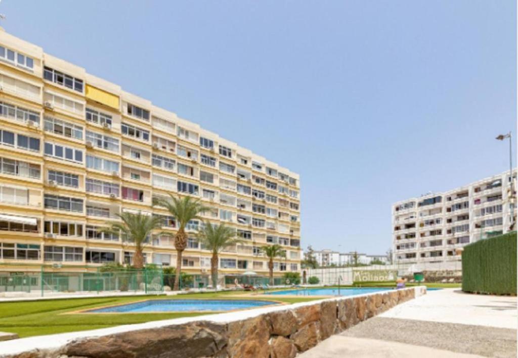 a large building with palm trees in front of it at AH - Rayito II - Confort y diseño bajo el sol de Maspalomas in Maspalomas