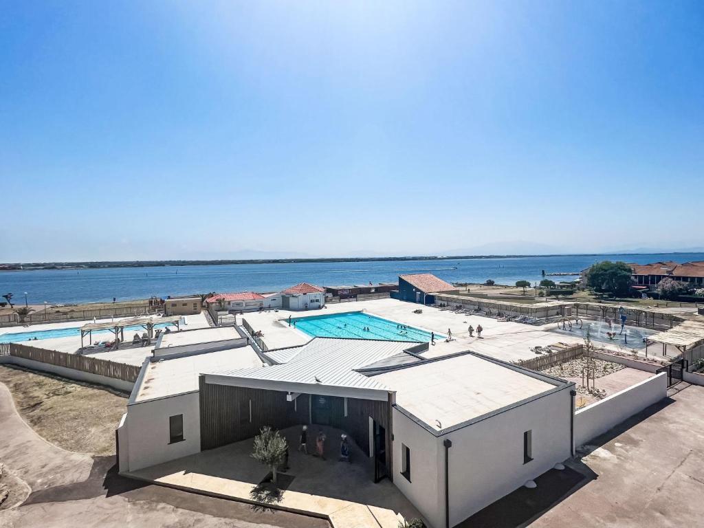 - un bâtiment avec une piscine à côté de l'eau dans l'établissement Apartment Coudalère-Guadeloupe-10 by Interhome, au Barcarès