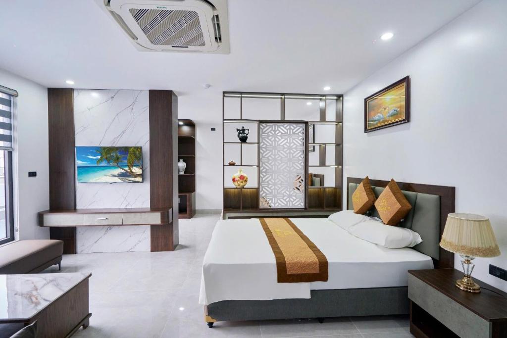 a bedroom with a king sized bed and a bathroom at Khách sạn Tân Trường Sơn in Sầm Sơn