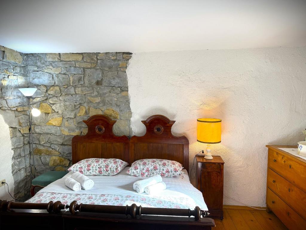 a bedroom with a bed and a stone wall at Kmetija Medljan in Izola