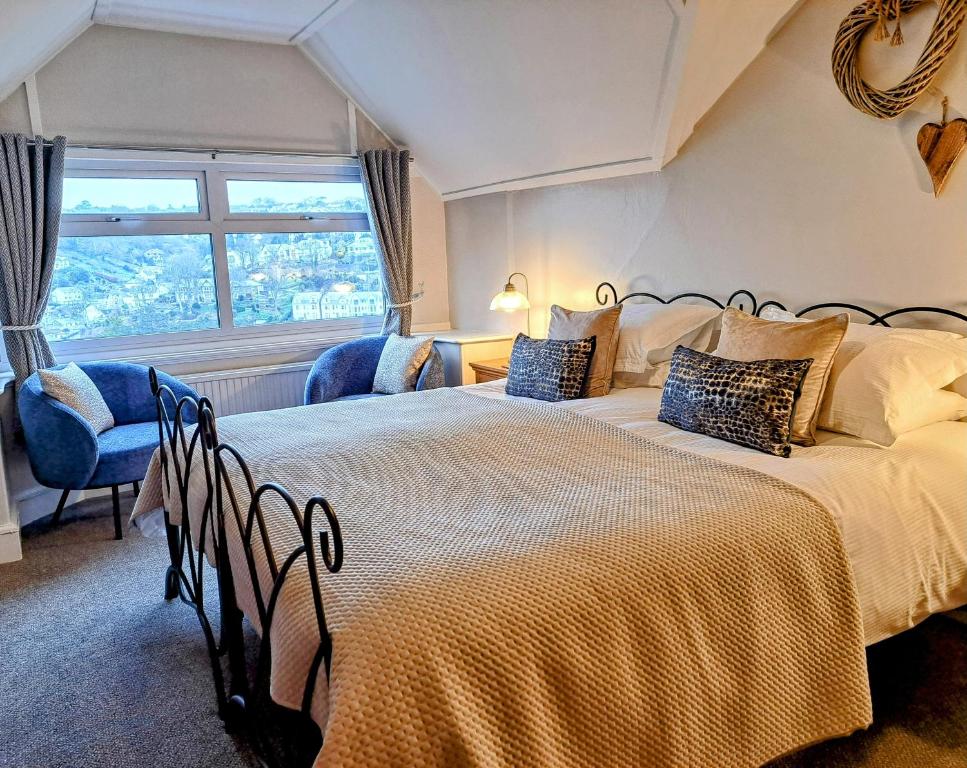 een slaapkamer met twee bedden en een raam bij Schooner Point Guest House in Looe