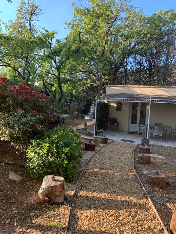 einen Hof mit einem Haus mit einer Veranda in der Unterkunft Le Petit Chene in Le Castellet