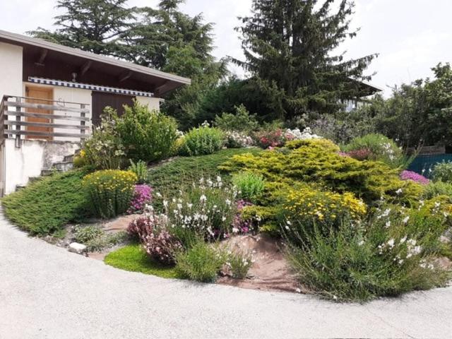 un jardin de fleurs et de plantes devant une maison dans l'établissement Villa proche du plan d'eau, à Embrun