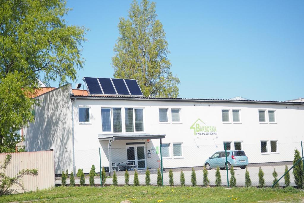 a white building with solar panels on the roof at Ubytování Barborka in Olomouc