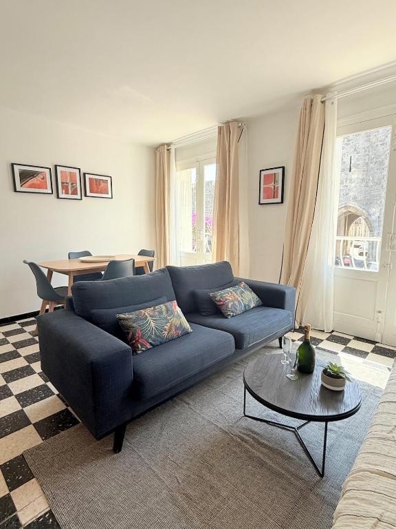 エーグ・モルトにあるAppartement au pied des rempartsの青いソファとテーブルのあるリビングルーム