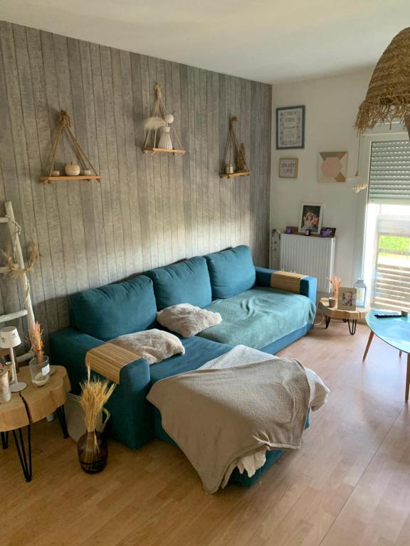 un salon avec un canapé bleu dedans dans l'établissement Appartement ensoleillé, à La Teste-de-Buch